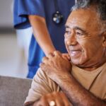 Nurse or doctor give man support during recovery or loss. Caregiver holding hand of her sad senior patient and showing kindness while doing a checkup at a retirement, old age home or hospital