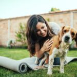 Girl playing with her beagle dog in yard.